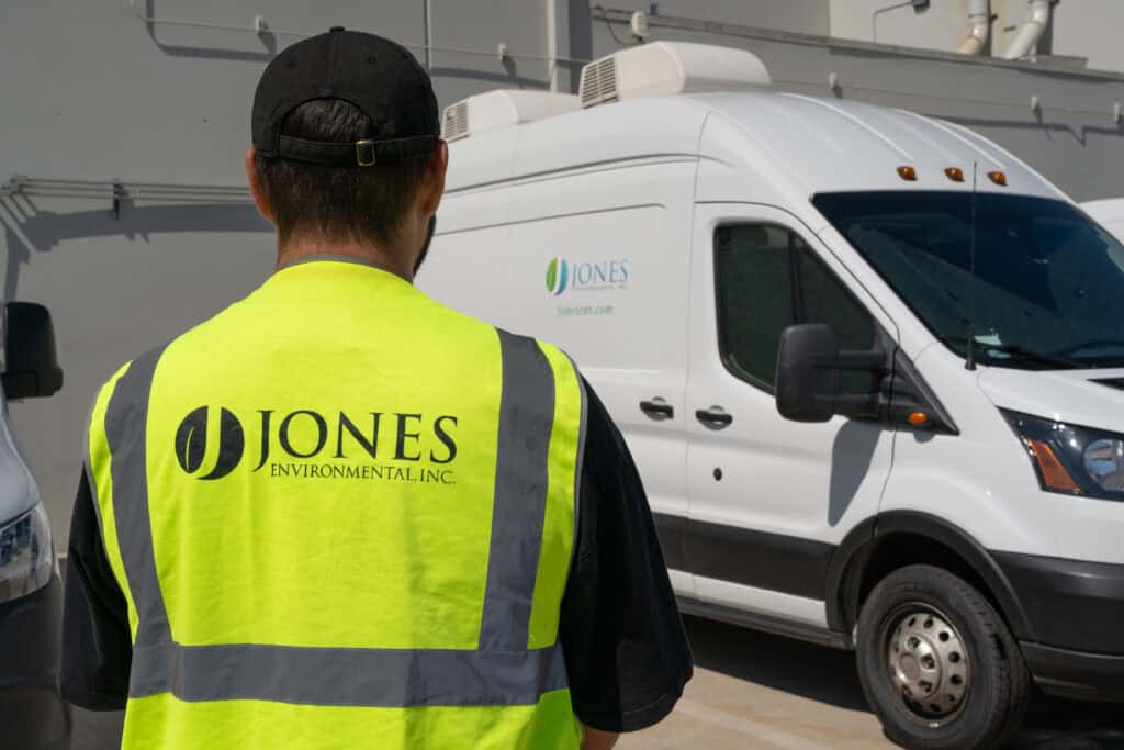 Jones Environmental field technician next to a mobile lab van